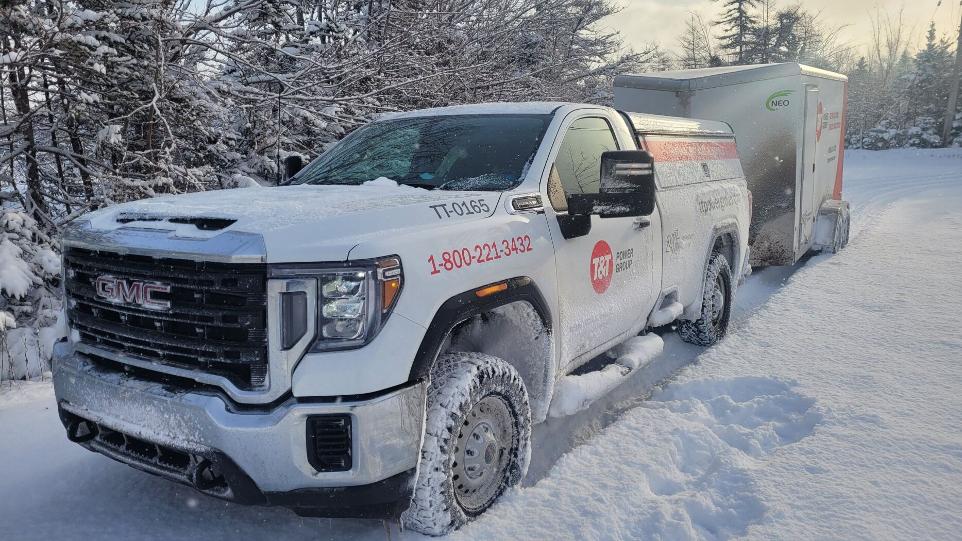 T&T Power Group pickup truck outside in the snow pulling a trailer